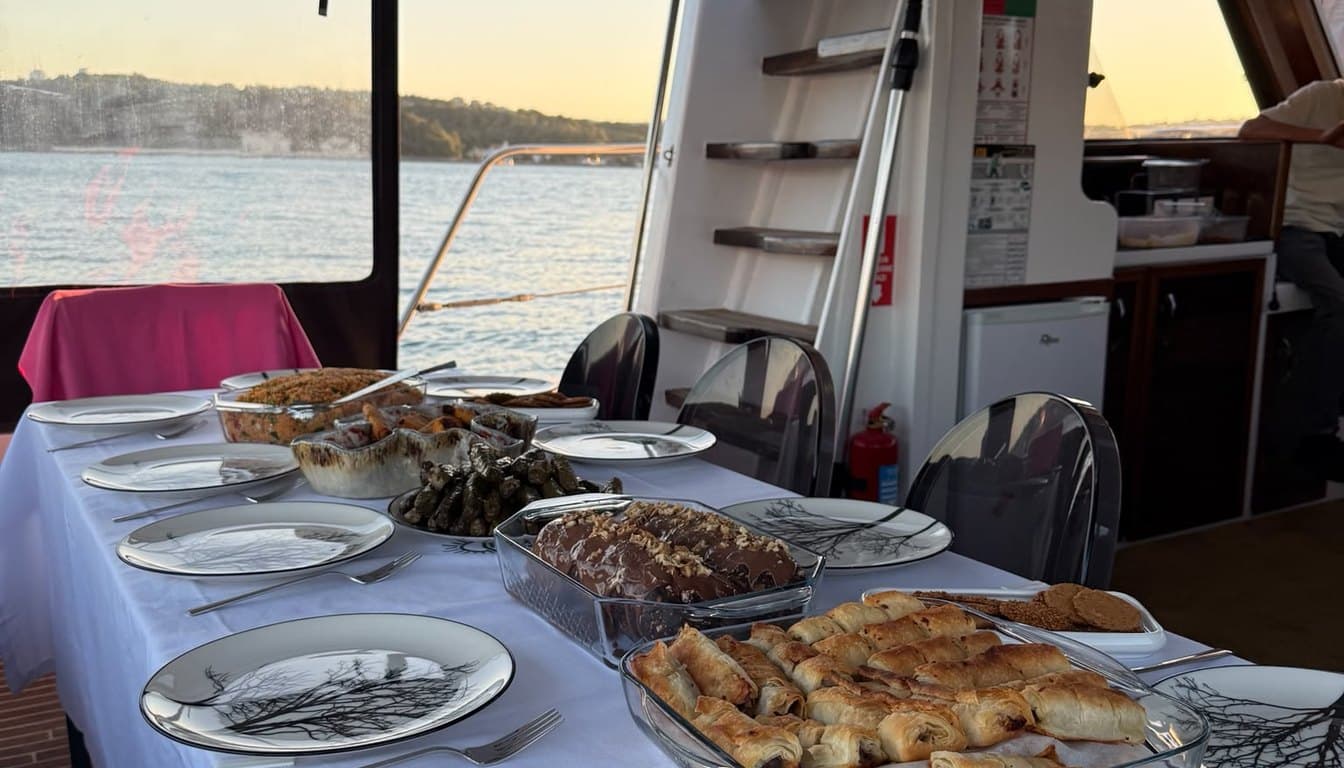 İstanbul Boğazı'nda gün batımında süzülen küçük özel yat ve güvertede dinlenen konuklar